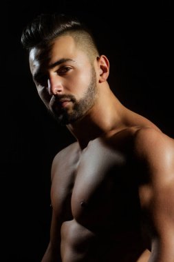 Siyah arka planda zayıf kaslı erkek model. Stüdyoda formasız poz veren adam. Karın kası olan bir adam. Karın kaslı, spor mankeni olan vahşi seksi bir adam. Kaslı adam.