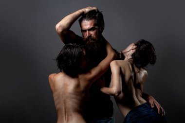 Üçlü konsept. Üç seksi model birlikte. Bir erkek ve iki seksi kadın. Çok eşlilik ya da iki eşlilik. Eş değiştiren ya da üçlü. Biseksüel kadın. Fahişelik ya da fantezi. Poliyamory ve çok eşlilik. Üçlünün Romantiği