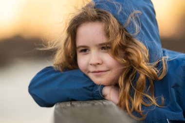 Hayalperest çocuk temiz havanın tadını çıkarıyor. Tasasız bir çocuğun portresi. Hayal gücünde sarışın bir çocuk. Huzurlu çocuk doğada dinleniyor. Geleceği düşünen bir çocuk. Küçük şirin hayalperest portresi. Çocuk yüzü