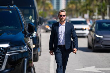 Lüks bir arabanın yanında zengin bir işadamı. Zengin bir iş adamı. Zarif zengin iş adamı. Pahalı arabası olan bir yönetmen. Premium arabada duran zengin bir işadamı. İş başarısı. Zenginlik kavramı