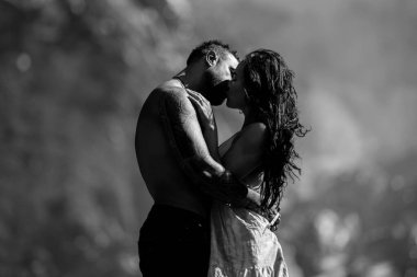 Aşık romantik çift doğaya tutkuyla sarılıyordu. Romantik çift doğayı öpüyor. Yaz doğasına aşık romantik çift. Romantik bir çiftin açık hava portresi. Doğaya şefkatli bir öpücük