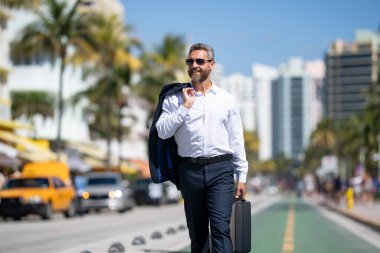 İş adamı işe yürüyerek gider. İspanyol işadamı sokakta güvenle yürüyor. Ofis çalışanı ofise gidiyor. Orta yaşlı iş adamı şehirde yürüyor. Yazlık kıyafetli bir iş adamı.