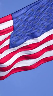 Mavi gökyüzünde dalgalanan Amerikan bayrağı. Birleşik Devletler bayrağı. Rüzgarda bayrak. Amerika 'nın vatansever bayrakları. ABD ulusal sembolü. Özgürlük ve demokrasi. Bağımsızlık Günü. Yıldızlar ve çizgiler. ABD bayrağı sallıyor