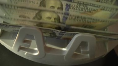 Kapatma para sayma makinesi dolar sayıyor. Ağır para sayma makinesi 100 dolarlık banknotları sayıyor. Para sayma makinesi. Finans bankacılığı kredi mevduat nakit