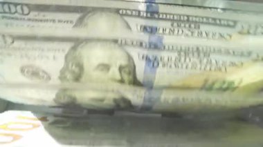 Para sayma makinesini kapat ve dolarları say. Banknot sayacı. Dolar banknotları olan para sayacı. Para sayma makinesi 100 dolarlık banknotları sayıyor.