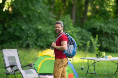 Adam ağaçların altında dinleniyor. Açık hava seyahati. Doğada kamp yapmak. Doğadaki özgürlük. Yaz kampı. Yürüyüş ve kamp macerası. Açık hava yaşam tarzı ve rahatlama. Ormanda bir tatil. Seyahatte dinleniyorum.