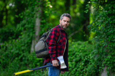 Ormanda baltası olan oduncu adam.