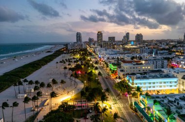 Miami Sahili Günbatımı hava manzarası. Alacakaranlıkta Miami 'nin göbeğinde. Güney Sahili neon ışıkları. Tropik Miami kıyısı manzarası. Ocean Drive Art Deco binaları. Miami kıyı şeridinin havadan görüntüsü