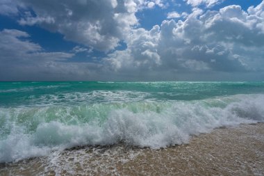 Turkuaz deniz dalgası hareketi. Yaz plajı. Sakin deniz. Güzel bir gökyüzü ve sahilde dalgalar. Güzel köpüklü kıyı şeridi. Deniz arka planı. Mavi okyanus. Kumlu okyanus plajı. Deniz dalgaları