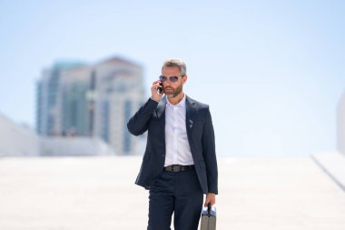 Zengin iş adamı dışarıda dolaşıyor. Çantası olan başarılı bir iş adamı. Lider harekete geçti. İş adamı güvenle yürüyor. Takım elbiseli bir iş adamı işe gidiyor. İş adamı profesyonel hareket halinde