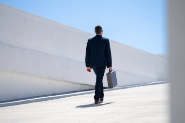 İş adamı tekrar dışarı çıkıyor. Takım elbiseli başarılı bir iş adamı. Kendine güveni tam bir iş adamı. İşadamı çekip gidiyor. Takım elbiseli zengin adam. Çantası olan şehirli iş adamı.