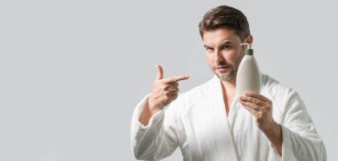 Kozmetik güzellik malzemeleri. Sıvı sabun, jöle ya da köpük pompalı kozmetik şişeli güzellik uzmanı. Başlık için afiş, kopyalama alanı. Web tasarımı için poster. Adam yeni kozmetik reklamı yapıyor.