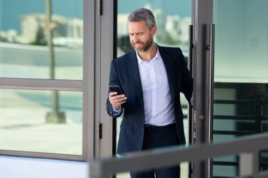 İş adamı bir ofis binasına giriyor. Yetişkin bir iş adamı toplantıya giriyor. İş adamı ofis kapısından içeri giriyor. Karizmatik iş adamı kapıdan giriyor. İş anlaşması