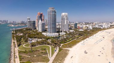 Miami 'de kumsalda güneşli yataklı, okyanus dalgalı bir plaj. Muhteşem manzaralı Miami Beach cenneti. Güney Sahili Miami cankurtaranı. Miami 'de huzurlu bir deniz kenarı inzivası. Kıyı gevşemesi