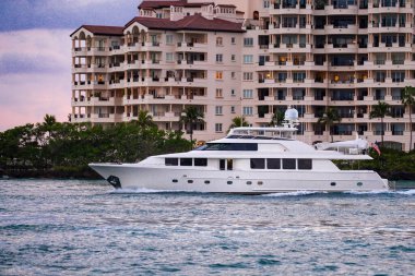 Deniz sularında yelken açmak. Denizde lüks bir yat. Yatları olan Miami Plajı. Yelkenli deniz pelerini. Sahil şeridine yakın bir gemi turu. Florida 'da gün batımı yat yolculuğu. Lüks yelkenli yat.
