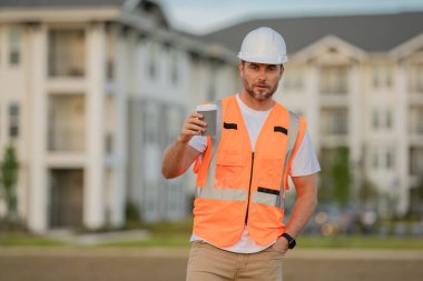 İnşaatçı inşaat alanında. Sert şapkalı bir adam. Yeni bina inşaatında miğferli inşaat işçisi.