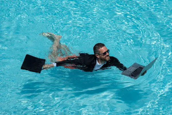 Takım elbiseli çılgın iş adamı havuzda dizüstü bilgisayar kullanıyor. Bilardoda çalışan çılgın bir serbest yazar. Deniz sahilinde dizüstü bilgisayarı olan komik bir iş adamı. Yaz seyahati ve plaj. Yaratıcı çevrimiçi strateji