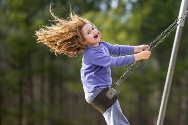 Çocuk salıncakta eğleniyor. Çocuk bahçesinde mutlu bir çocuk. Kaygısız çocuk dışarıda sallanıyor. Mutlu çocuklar dışarıda oynuyor. Sarışın çocuk heyecandan titriyor. Dışarıdaki oyuncu çocuk. Eğlenceli çocuk suratı