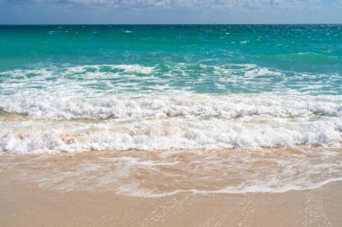 Deniz kumsalı. Manzaralı deniz sahili arkaplanı. Cennet okyanus manzarası. Köpüklü sahil arka planı. Egzotik okyanus. Açık deniz sahili ufku. Rahatlatıcı dalgalar. Yaz arkaplanı