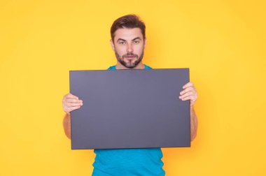 Stüdyo arka planında boş tahtası olan bir adam. Kopya alanı olan boş tabela. Reklam konsepti. Fotokopi alanı olan reklam panosu, boş kopya alanı. Boş tabela, kopyalama alanı olan pano