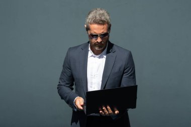 Dizüstü bilgisayarda çalışan bir iş adamı. Şehirde dizüstü bilgisayar kullanan kendine güvenen bir adam. Dizüstü bilgisayarda yazan takım elbiseli bir yönetici. Uzaktan kumandalı başarılı bir girişimci. İş adamı dizüstü bilgisayardaki e-postaları kontrol ediyor