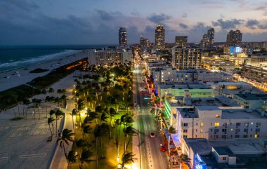 Miami Sahili Günbatımı hava manzarası. Alacakaranlıkta Miami 'nin göbeğinde. Güney Sahili neon ışıkları. Tropik Miami kıyısı manzarası. Ocean Drive Art Deco binaları. Miami kıyı şeridinin havadan görüntüsü