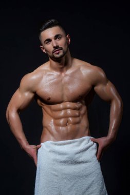 Siyah arka planda zayıf kaslı erkek model. Stüdyoda formasız poz veren adam. Karın kası olan bir adam. Karın kaslı, spor mankeni olan vahşi seksi bir adam. Kaslı adam.