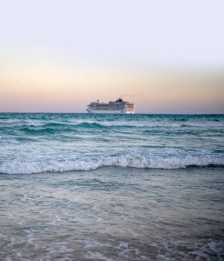 Okyanusta bir gemi turu. Okyanusta lüks bir yolcu gemisi. Yolcu gemisi olan Miami Plajı. Turkuaz su ve yolcu gemisi. Kıyıya yakın bir turist gemisi. Okyanus dalgaları ve gemi teknesi
