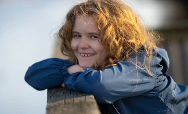 Hayalperest çocuk temiz havanın tadını çıkarıyor. Tasasız bir çocuğun portresi. Hayal gücünde sarışın bir çocuk. Huzurlu çocuk doğada dinleniyor. Geleceği düşünen bir çocuk. Küçük şirin hayalperest portresi. Çocuk yüzü