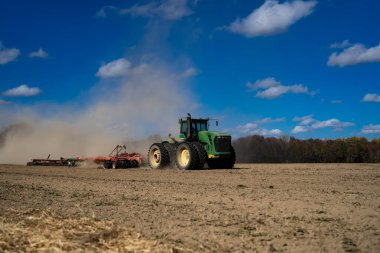 Traktör tarlada toprak sürüyor. Toprak üzerinde çiftçilik. Kırsal tarım arazilerinde traktör. Toprakta çalışan tarım makinesi ya da traktör. Çekici tarla sürme çiftliği. Çiftlik arazisi
