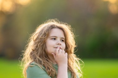 Çocuk başka tarafa bakıyor ve düşünüyor. Çocuk hayalperesti şüpheli bir bakışla düşünüyor. Derin düşünen bir çocuğun portresi. Hayalperest ergen çocuk düşüncelere daldı. Düşünceli yüzlü zeki çocuk. Hayal kuran çocuk