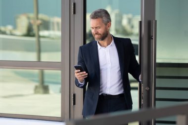 İş adamı bir ofis binasına giriyor. Yetişkin bir iş adamı toplantıya giriyor. Ofis kapısından giren bir iş adamı. Karizmatik iş adamı kapıdan giriyor. İş anlaşması