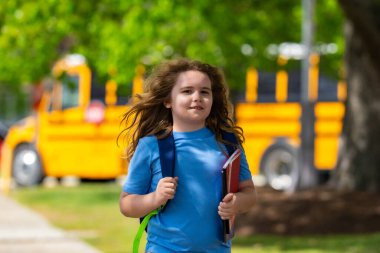 Okula dönelim. Genç öğrenciler için okul başlıyor. Okul otobüsünün yanında sırt çantalı bir çocuk. Çocuk okula gidiyor. Çocuk derse gidiyor. Okul çocuğu.