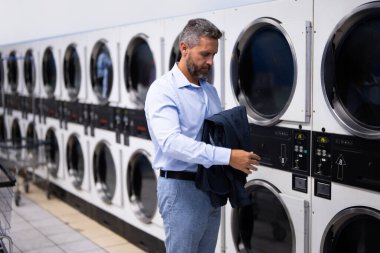 Yoğun program ve zaman yönetimi. Planlandığı gibi etkili bir planlama. Halka açık çamaşırhanede iyi organize olmuş bir adam. İş-yaşam dengesi. Yetişkin bir iş adamı için yoğun bir program. Yoğun zamanlama