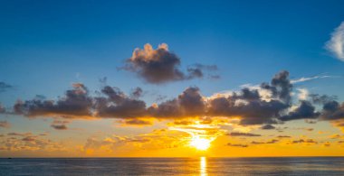 Gün batımında gökyüzü. Güneş ışığının arka planında güzel bir gün doğumu. Alacakaranlık, dramatik şafak, alacakaranlık, güneş ışığı. Bulutlu gün batımı. Gün batımı duvar kağıdı. Gökyüzü gün batımı örtüsü. Huzurlu ufuk. Parlak gökyüzünün manzarası