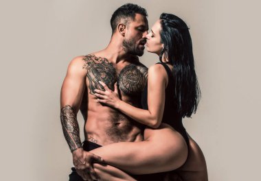 Gömleksiz, kaslı bir adam kız arkadaşını kucaklıyor. Şehvetli kadın ve erkek kucaklaşması. Seksi çiftler portresi. Aşık seksi bir çift. Sevgililer sarılıyor. Şefkatli bir çift. Birkaç şehvetli dokunuş