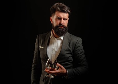 Ciddi bir adamın elindeki brendi bardağı. Barda tek başına brendi içen adam. Klasik klasik bardakta konyak konyağı. Brendi viskisi retro tarzında. İçki konsepti