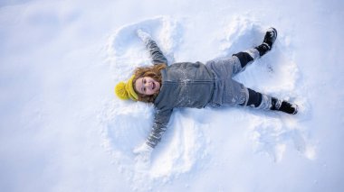 Kar meleği yapan bir çocuk. Karda yatan mutlu çocuk. Kardaki melek çocuk. Karlı melek kanatlı kış çocukları. Karlı bir günde gülümseyen bir çocuk. Kar Gölü Meleği 'ndeki kaygısız çocuk. Noel neşesi