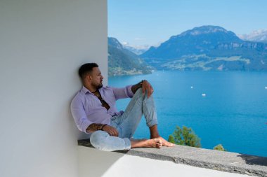 Kaslı bir adam dağ Alpleri manzarasında rahatlar. Alp Gölü 'nde yakışıklı bir turist. Yazın poz veren güçlü, seksi bir adam. Hayalperest, kaygısız bir gezgin. Açık havada insan özgürlüğü