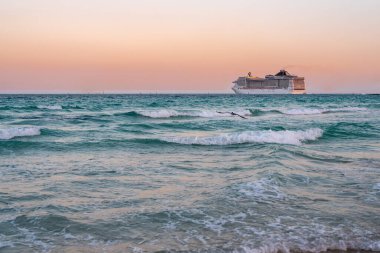 Okyanusta bir gemi turu. Günbatımında lüks bir yolcu gemisi. Yolcu gemisi olan Miami Plajı. Turkuaz su ve yolcu gemisi. Kıyıya yakın bir turist gemisi. Okyanus dalgaları ve gemi teknesi
