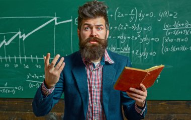 Öğretmen sınıfta matematiği açıklıyor. Profesör, matematik dersinde. Öğretmen matematik formülü yazıyor. Komik öğretmen. Profesör sınıfta ders veriyor. Öğretmen matematiği açıklıyor. Öğretmenler Günü