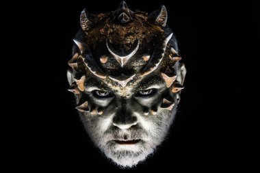 Şeytan boynuzlu adam. Gizemli adam, boynuzlu şeytan. Kara boynuzlu efsanevi şeytan portresi. Ürkütücü yüz. Cadılar Bayramı şeytanı bakışı. Cehennemden gelen kötülük. Doğaüstü güçleri olan bir büyücü. Ürkütücü yüz.