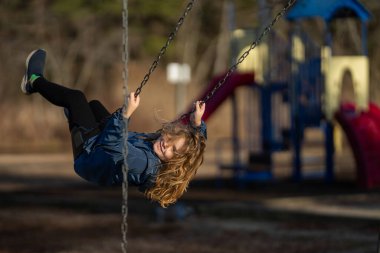 Çocuk salıncakta sallanıyor. Çocuk çocuk çocuk parkında sallanıyor. Parkta sallanan çocuk. Mutlu çocuk dışarıda oynamaktan hoşlanıyor. Sevimli çocuk oyun alanında eğleniyor. Çocuk parkında sallanıyor