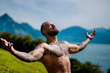 Doğada güçlü bir adam. Şelalenin altına sıçrayan seksi üstsüz adam. Formda ve güçlü bir erkek vücudu. Seksi manken yazın tadını çıkarıyor. Erkek güzeli. Su damlalı kaslı gövde. Manzarada üstsüz bir adam