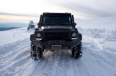 01.02.2021, Karpatlar. Gün batımında kar içinde off-road SUV. 4x4 jipli bir kış seferi. Kış doğasında zorlu bir off-road gezisi. Off-road arabalı dağ yolu. Kar yolunda macera gezisi