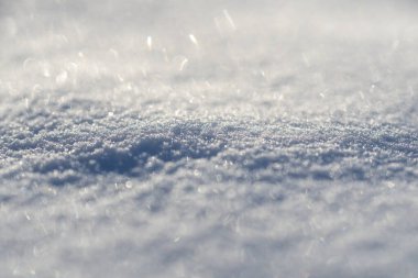 Kar arka planı kaplıyor. Kar kışın güzelliğini gösterir. Kar parlak ve beyaz görünüyor. Kar bütün gün donmuş olarak kalır. Karlı bir desen. Kar tanesi düşüyor. Soğuk ve buzlu arka plan.