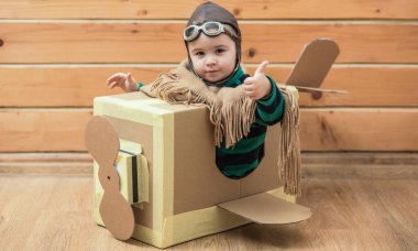 Çocuk hayal gücü kavramı. Hayali kanatlı bebek sineği. Çocukların hayal gücü macerası. Hayalperest çocuk uçmayı hayal eder. Karton kanatlar hayal gücünü harekete geçirir. Yaratıcı çocuk pilot hayal gücü