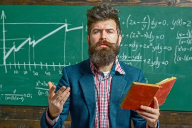 Öğretmen sınıfta matematiği açıklıyor. Profesör, matematik dersinde. Öğretmen matematik formülü yazıyor. Sakallı öğretmen. Profesör sınıfta ders veriyor. Öğretmen matematiği açıklıyor. Öğretmenler Günü