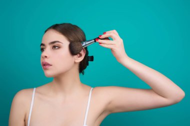 Beauty woman with makeup brushes. Make up for woman. Girl with makeup brushes near face. Cosmetic brush. Facial Makeup. Female model applying blush powder foundation tone