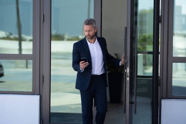 İş adamı bir ofis binasına giriyor. Yetişkin bir iş adamı toplantıya giriyor. İş adamı ofis kapısından içeri giriyor. Karizmatik iş adamı kapıdan giriyor. İş anlaşması